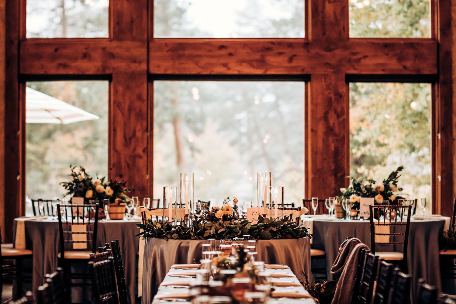 Romantic wedding reception venue with large windows and elegant table settings.