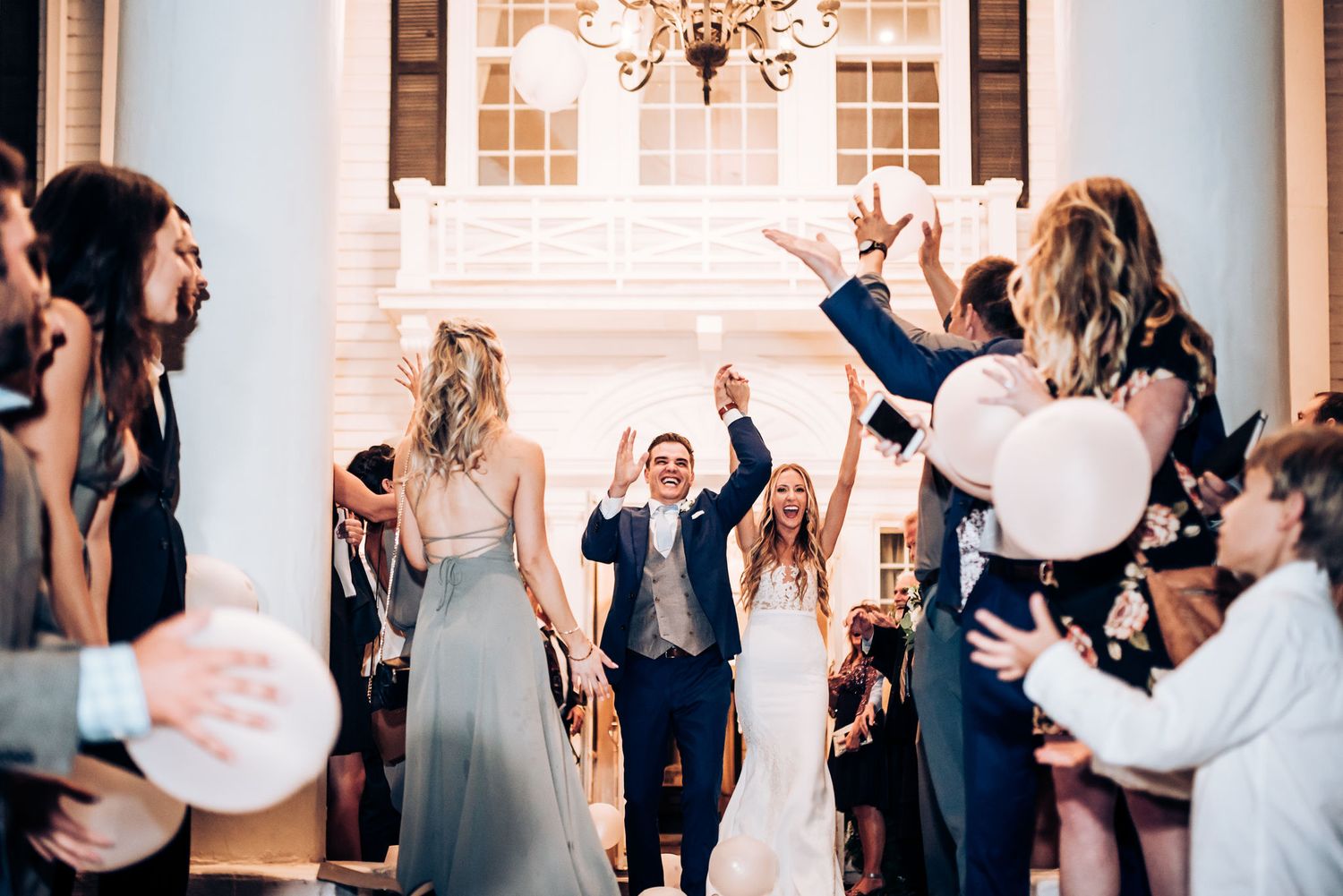 Wedding celebration scene with guests clapping and cheering in an elegant venue.
