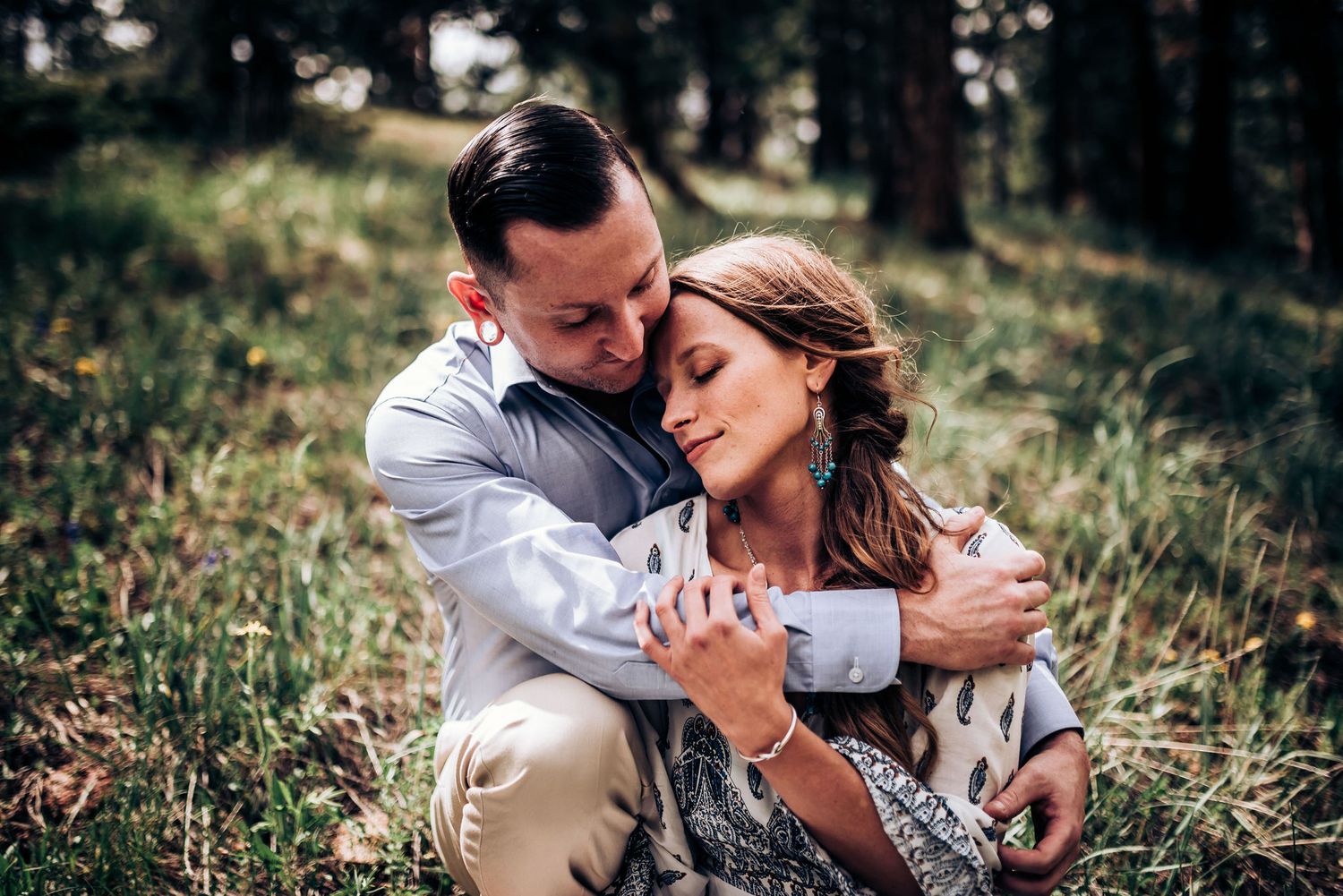 An intimate embrace captured in a serene forest setting.