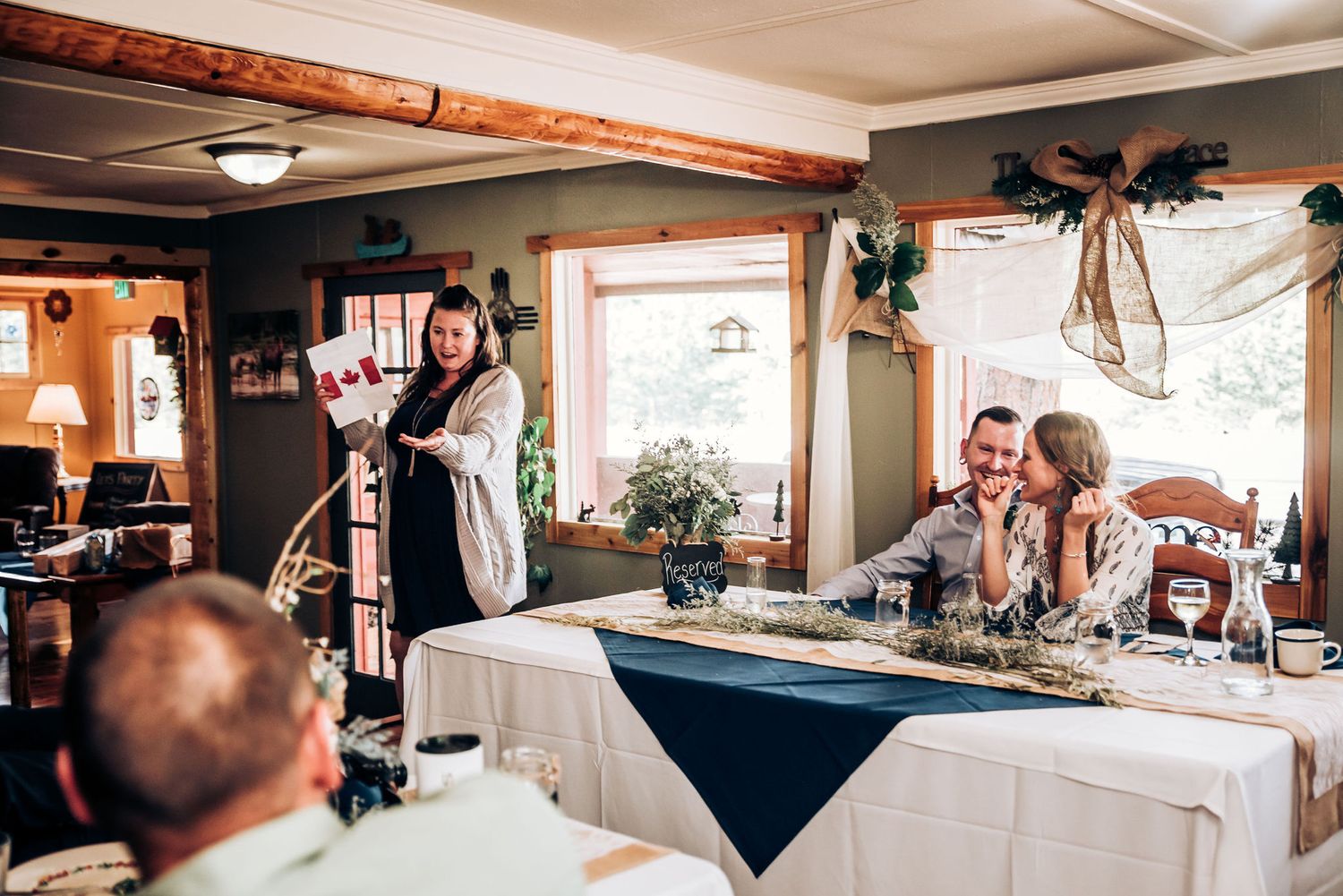 A reception speech being delivered at a venue decorated with navy blue and white table settings.