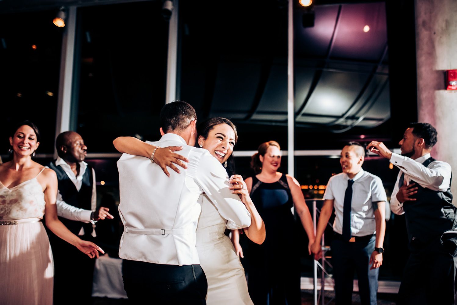 Wedding guests celebrate on the dance floor during a lively reception.