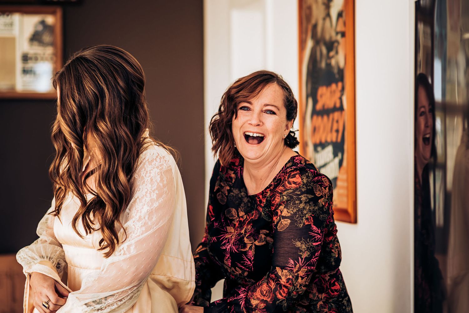A joyful candid moment shared between two people during wedding preparations.