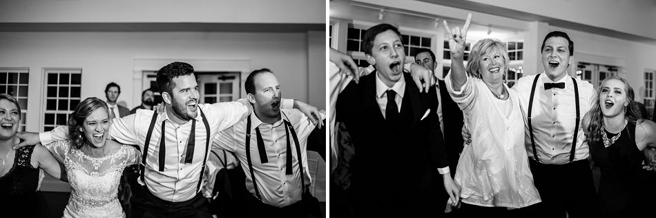 Wedding party celebrates with arms raised during lively reception exit.