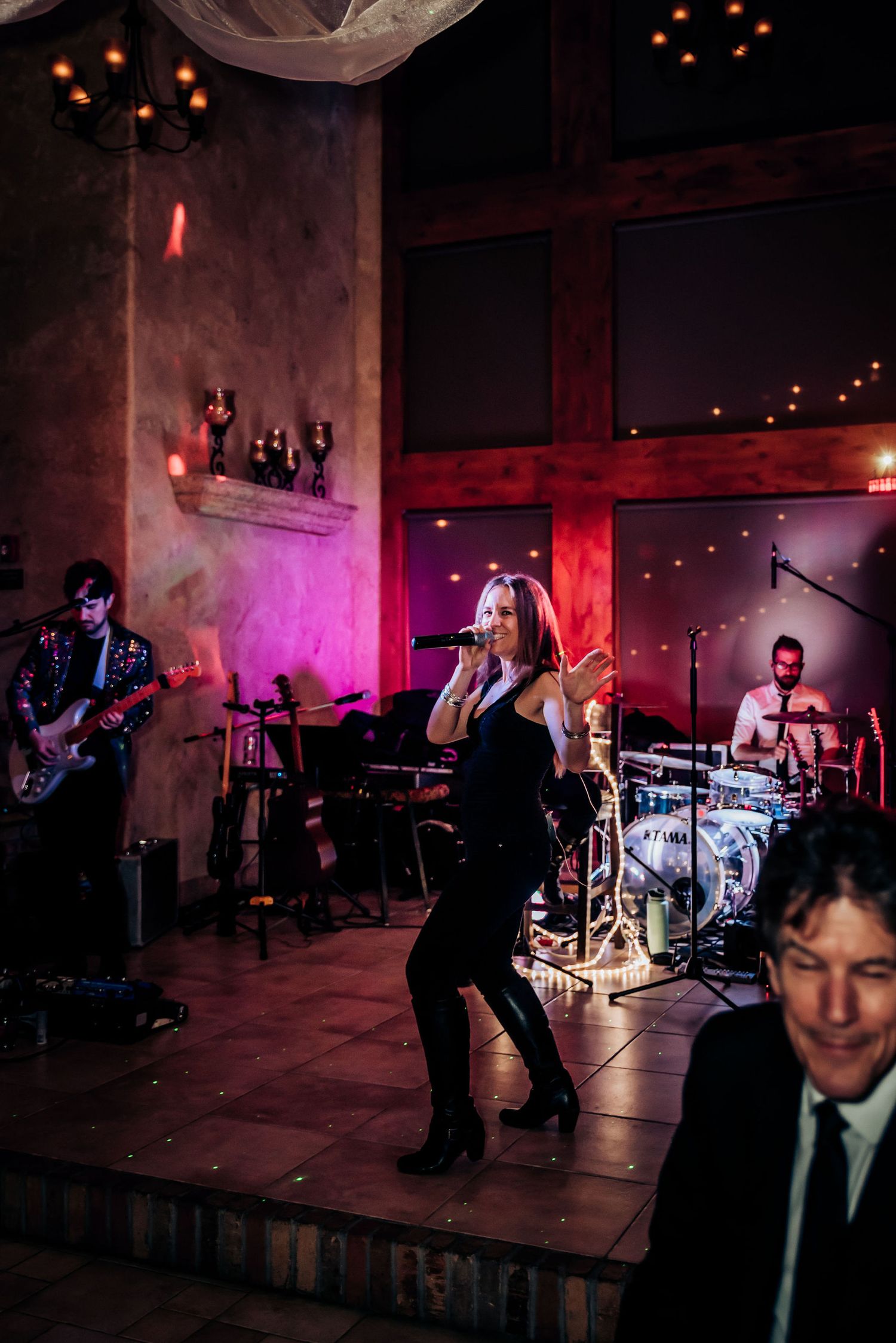 Band performs at a rustic venue with mood lighting and exposed wooden beams.