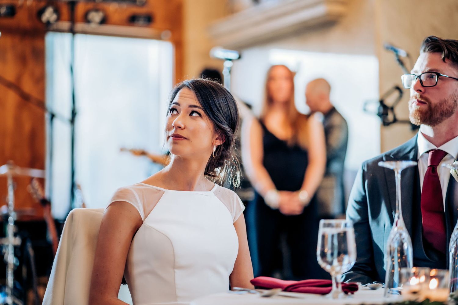 Wedding celebration in progress at an indoor venue with natural lighting and elegant decor.