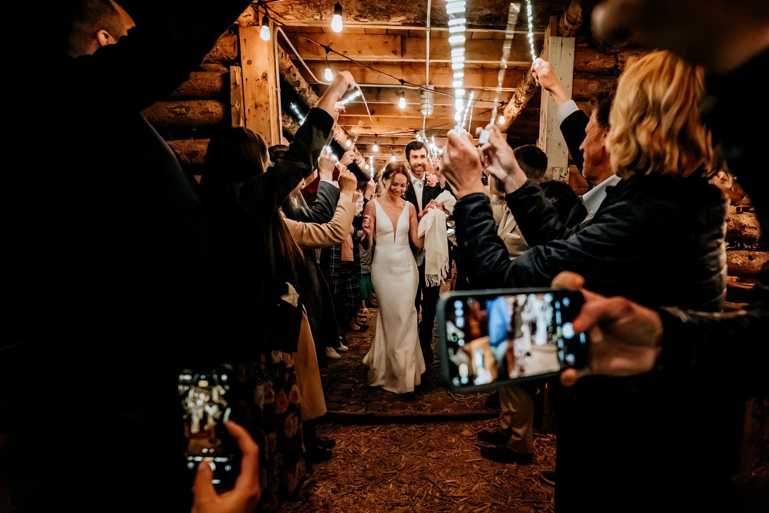 Wedding guests creating an illuminated pathway with light wands for the newlyweds.