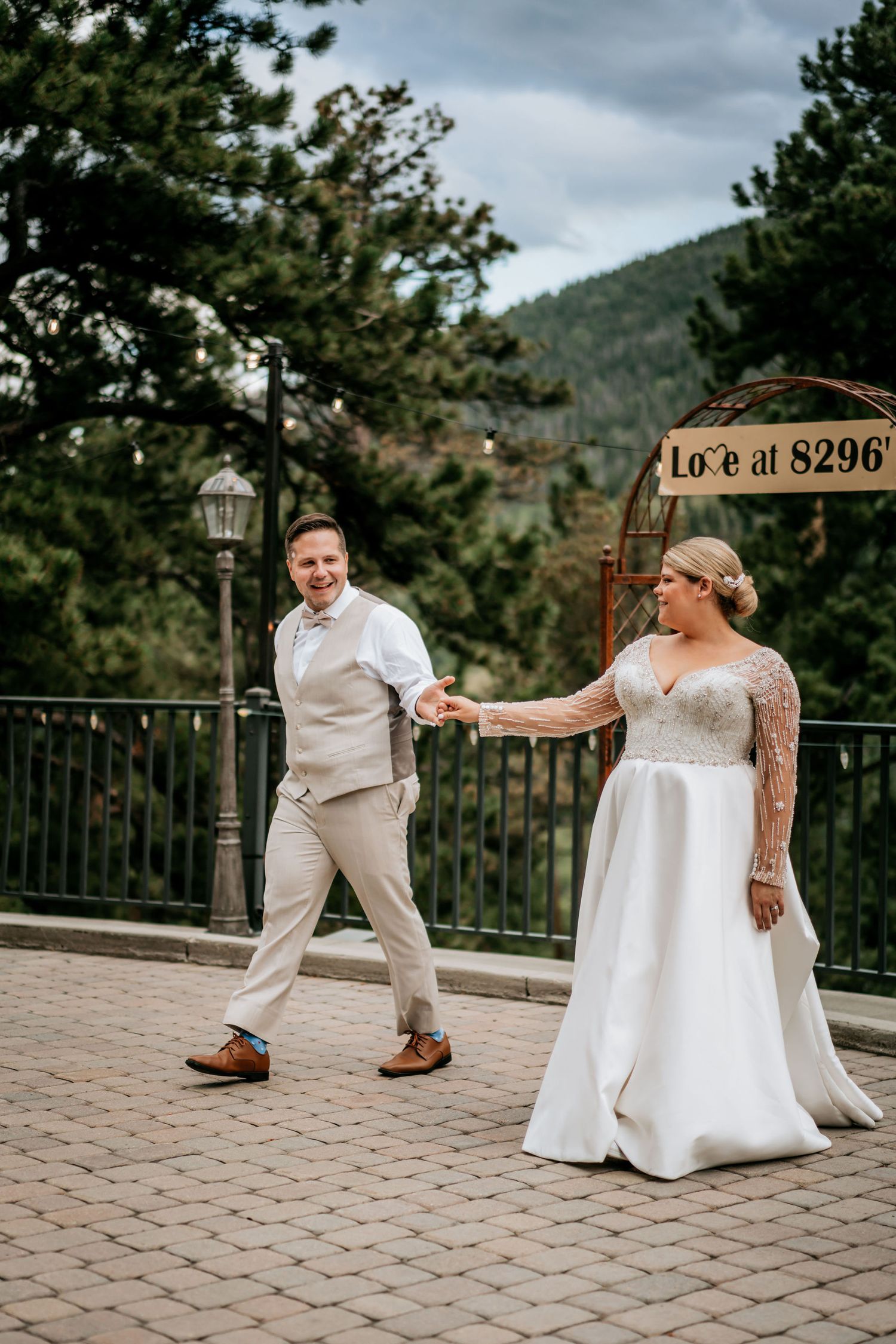 Wedding couple dancing on an outdoor terrace with mountain views.