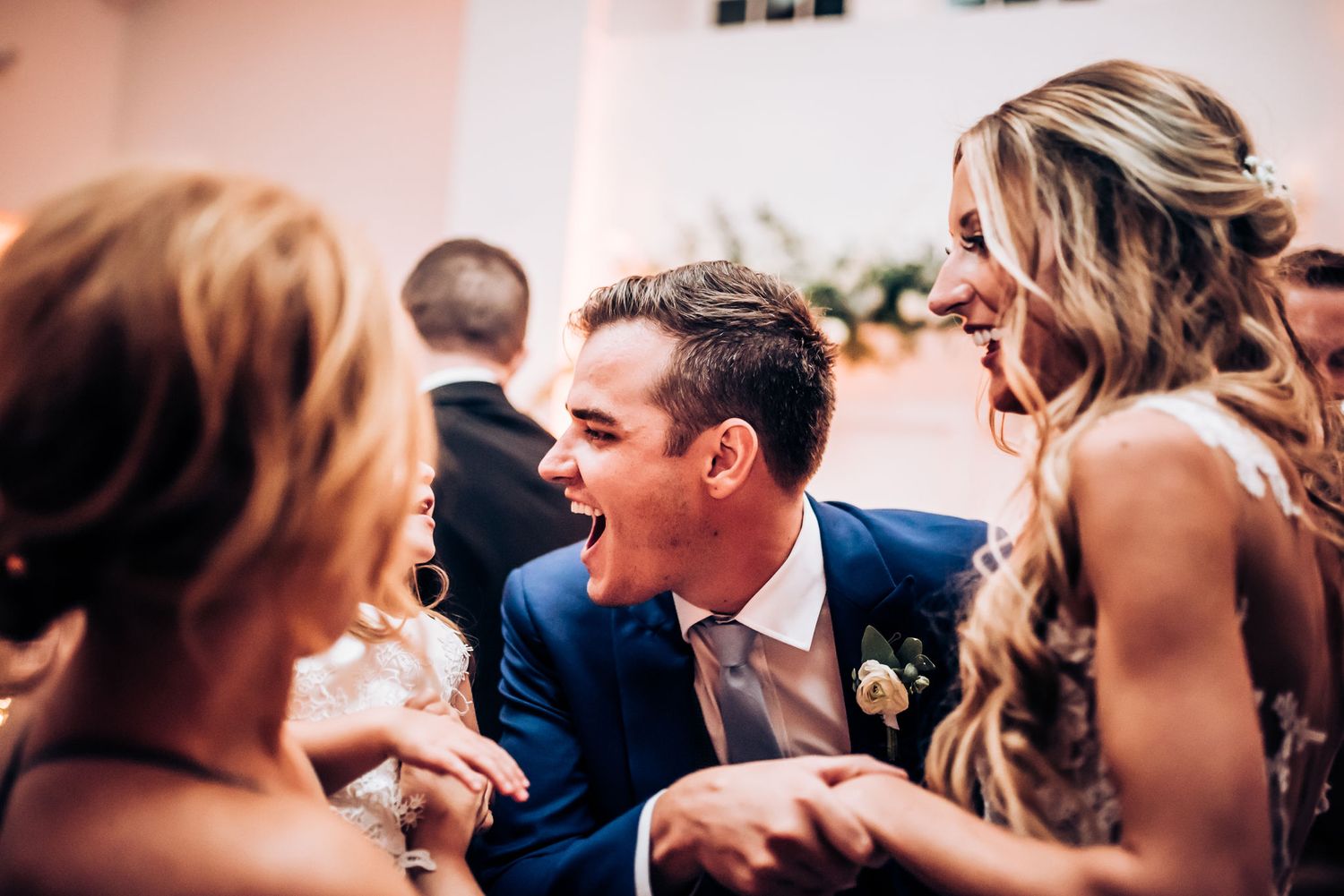 Guests share an animated conversation during a lively wedding reception celebration.