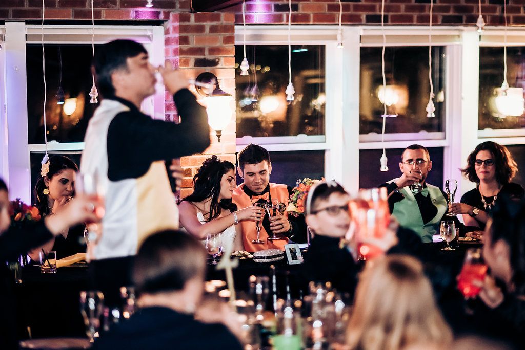 Entertainment performance at reception venue with audience seated at tables.