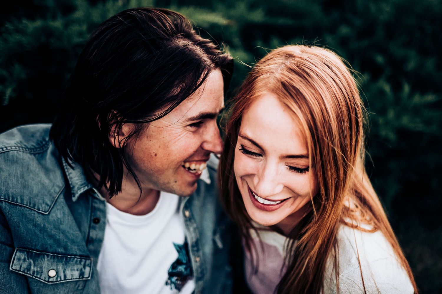An intimate moment between a couple as they share gentle laughter together.