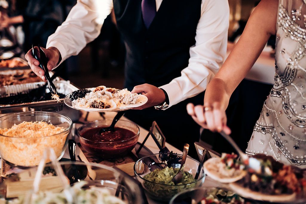 Guests serving themselves from an elegant buffet spread with various dishes and appetizers.