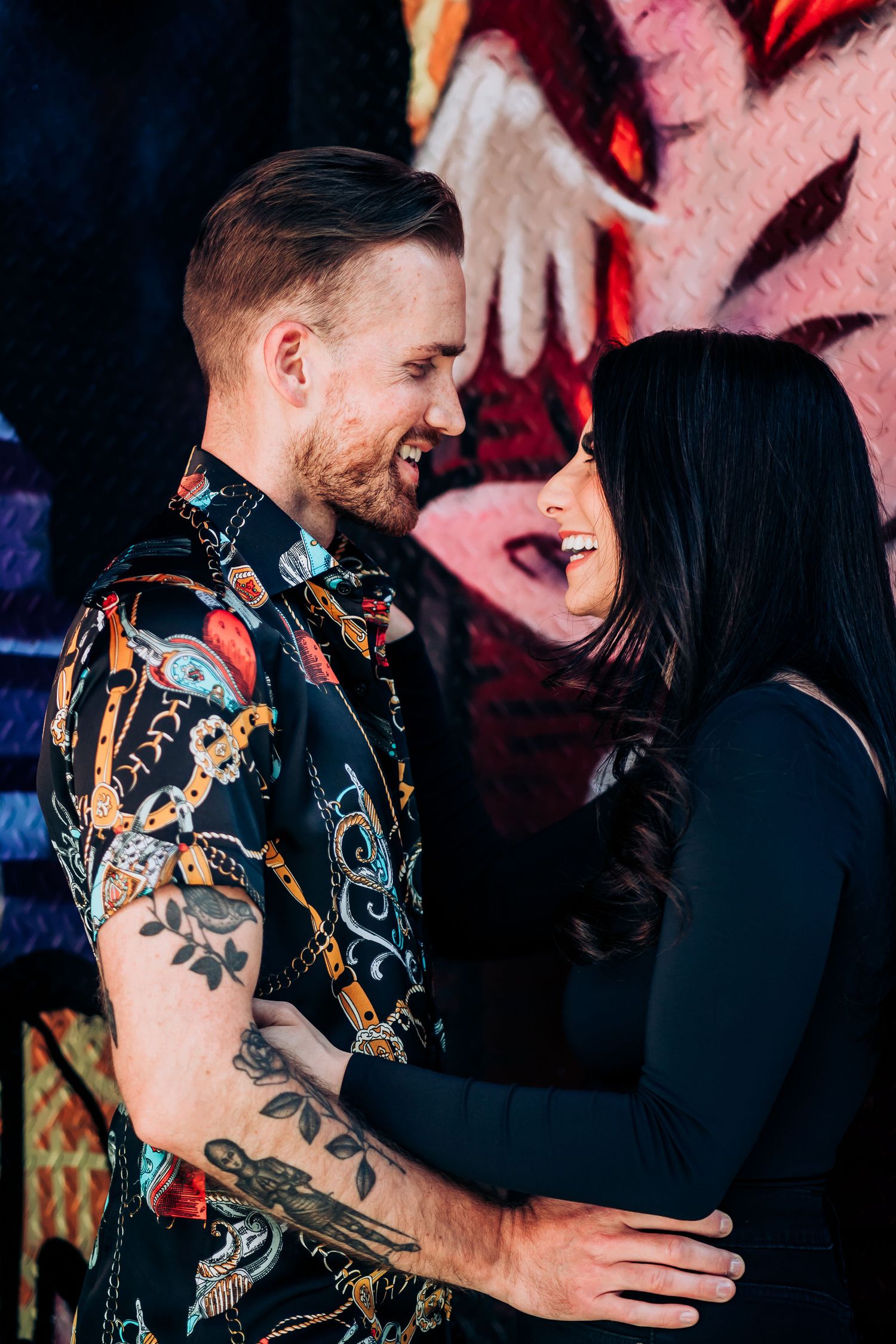 A couple sharing a tender moment against a colorful graffiti background.