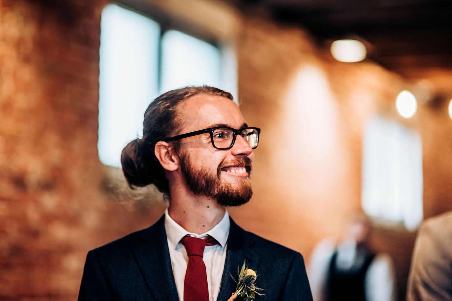 A joyful moment captured at a wedding in front of exposed brick walls.
