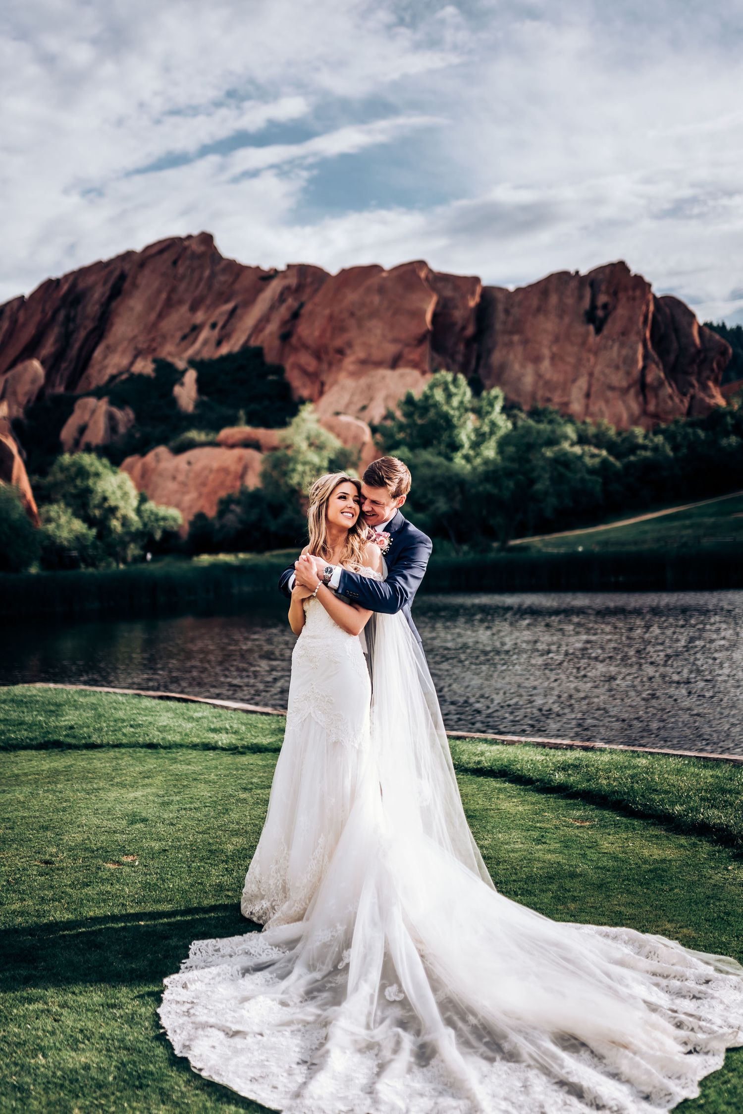 Beautiful wedding portrait with stunning red rock formations and lake reflections in background.