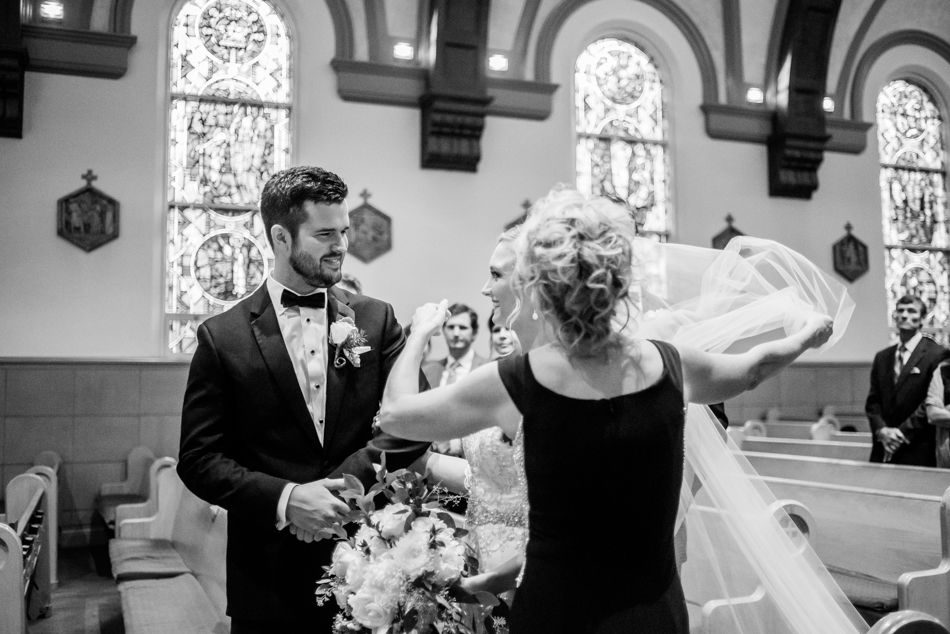 Black and white photo of joyful moment during traditional church wedding ceremony.