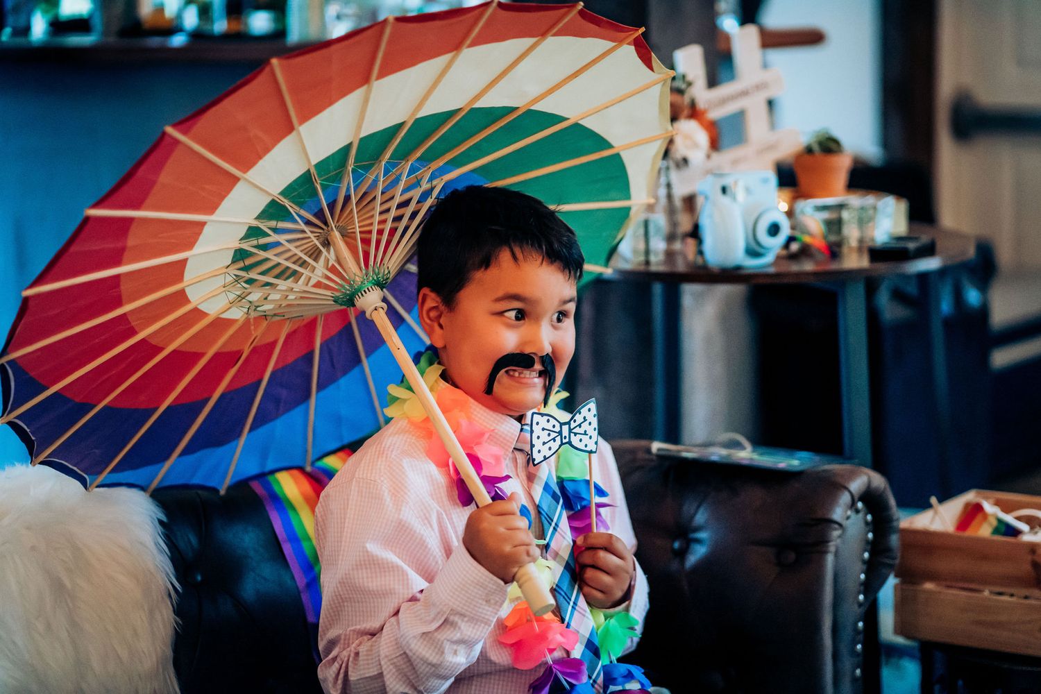 A colorful rainbow umbrella brings joy indoors during a celebration.