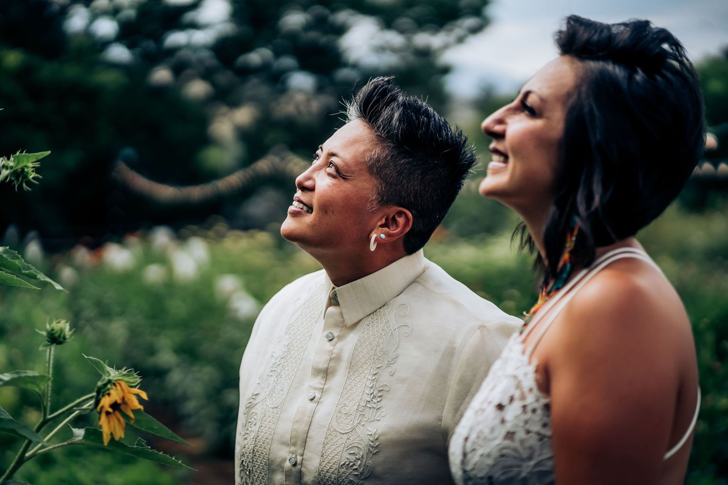 A candid moment of shared laughter in a sunlit garden with wildflowers.