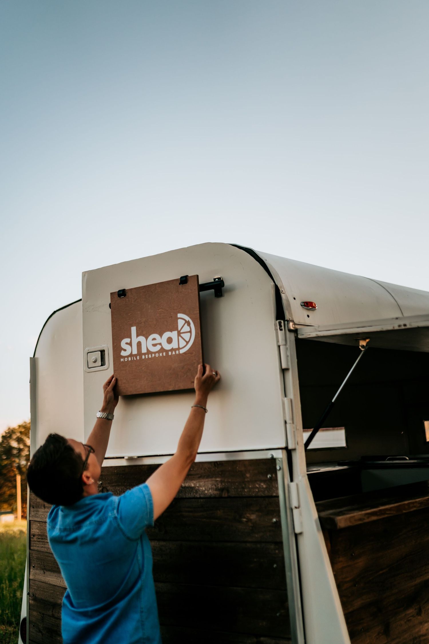 Mobile bar service trailer being set up at an outdoor event.