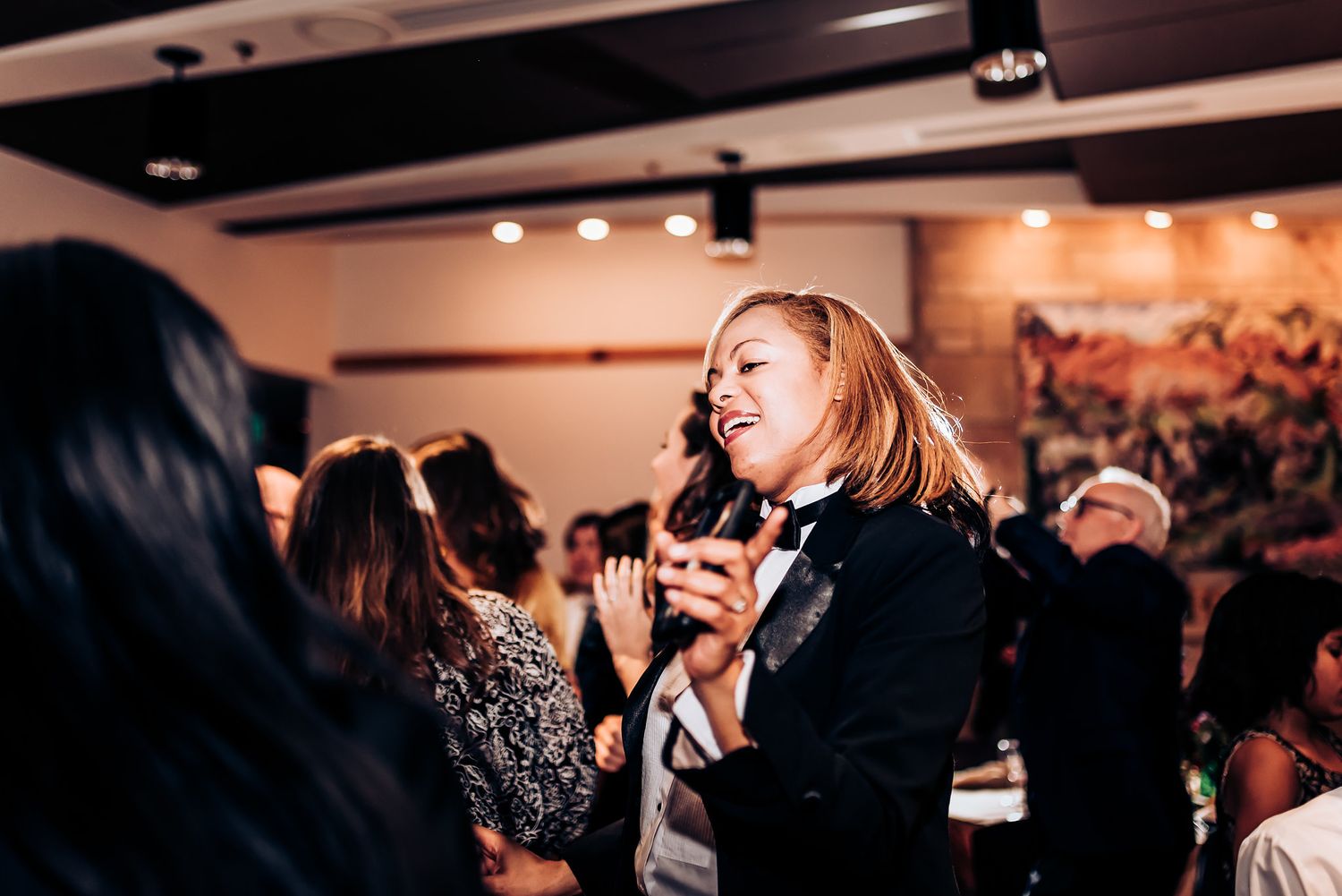 Guest singing and dancing energetically during a lively reception celebration.
