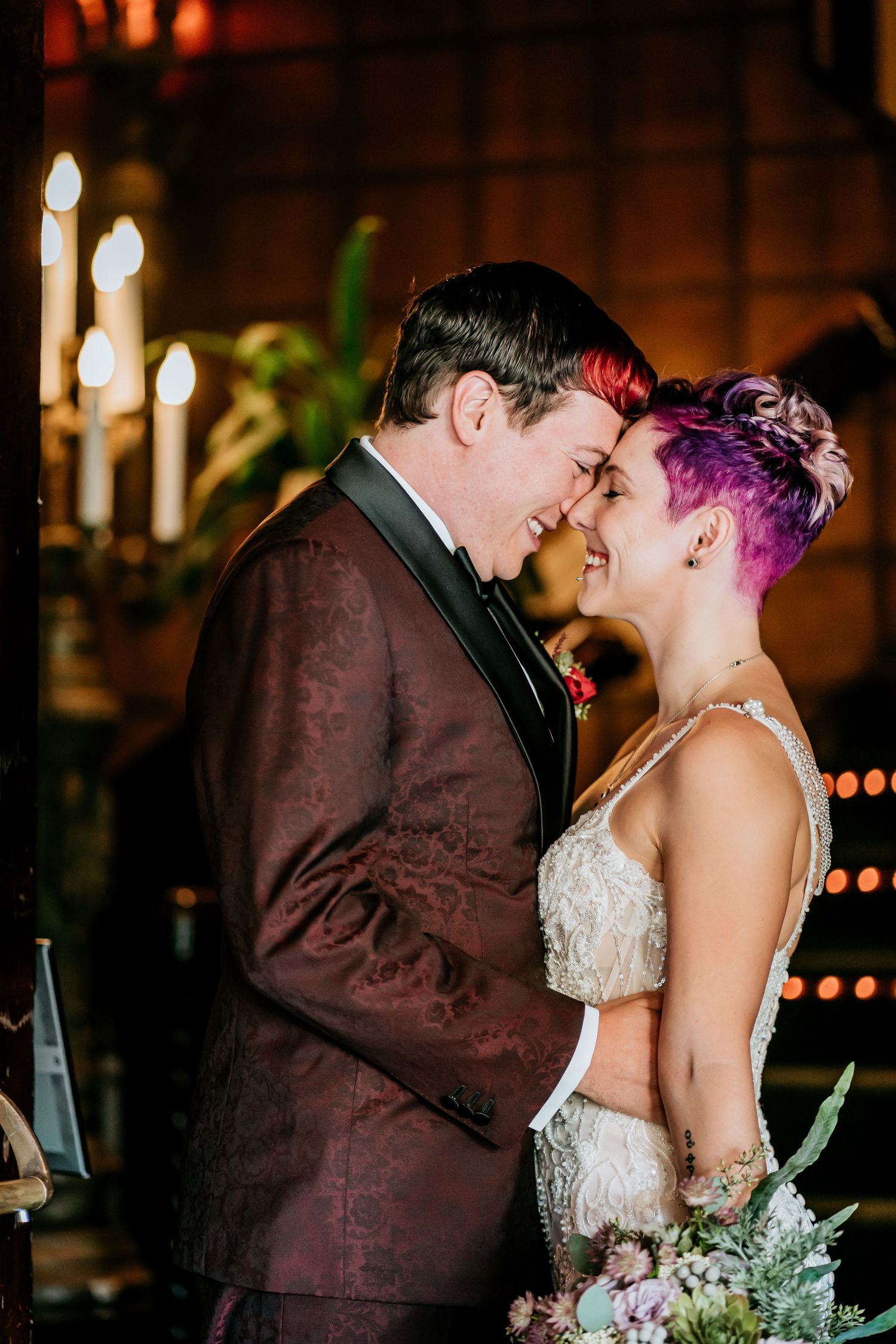Intimate wedding couple moment under warm lighting with bokeh effects.
