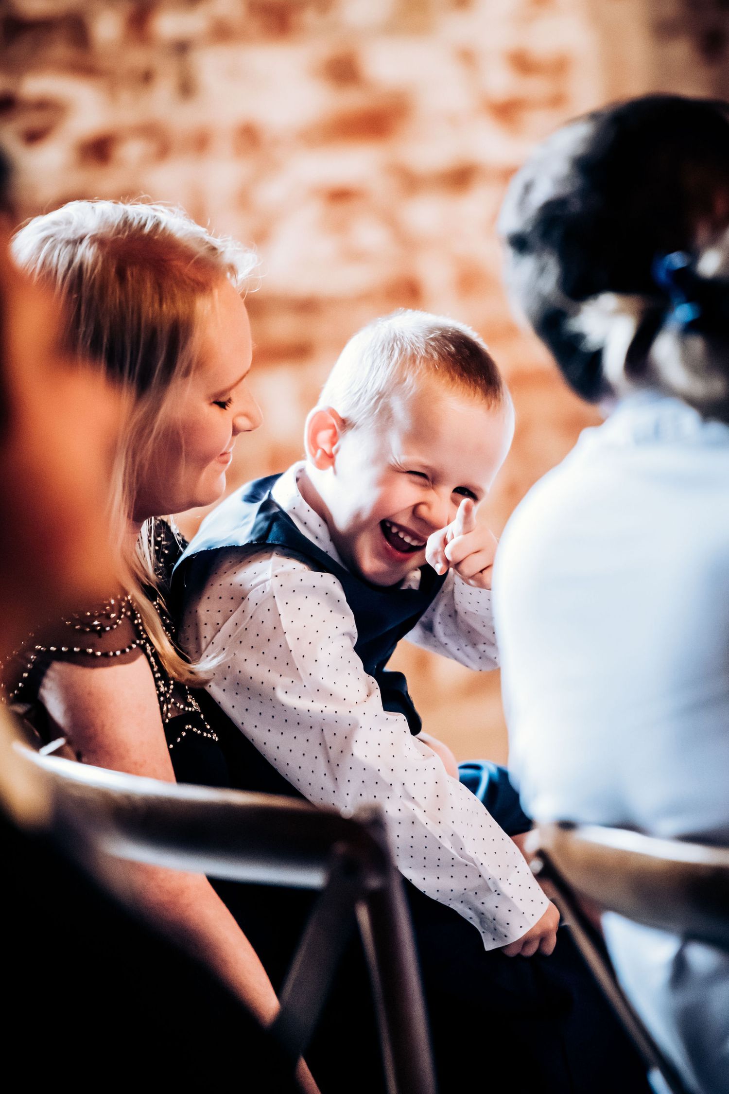 Guest sharing joyful moment during wedding reception in rustic venue setting.