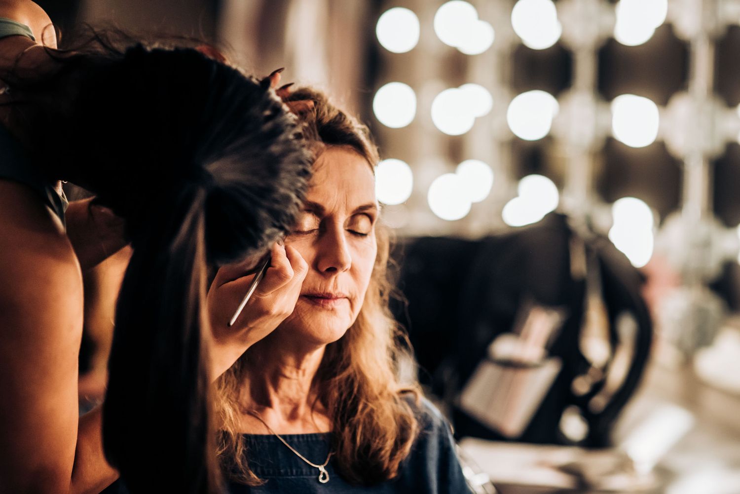 Makeup application in process with professional lighting and salon atmosphere.