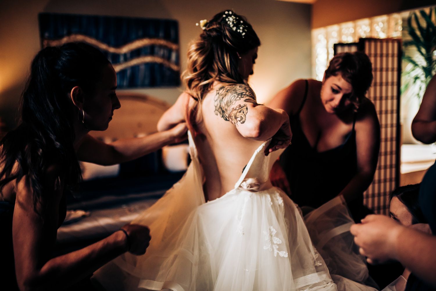 Wedding dress being laced up during bridal preparation.