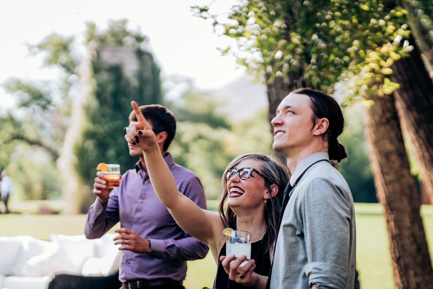 Guests enjoying drinks and conversation outdoors during a sunny afternoon event.