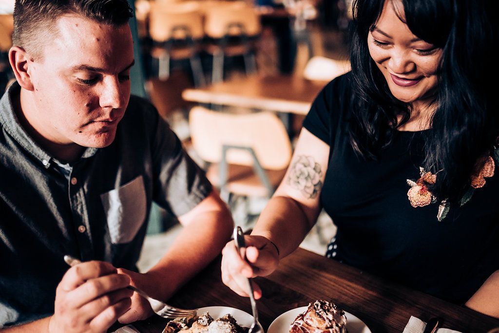 Two people examining food together at a restaurant table.