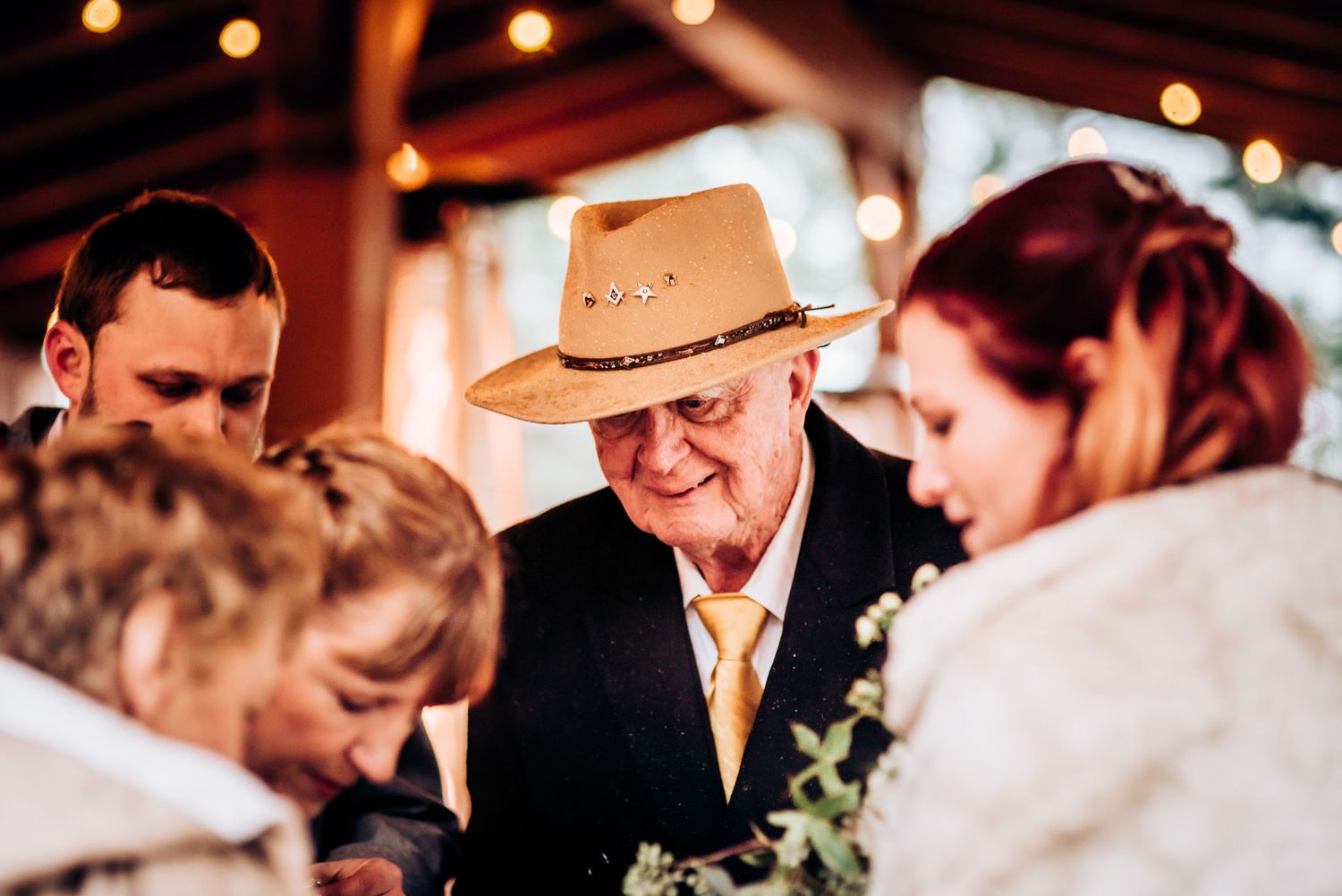 Candid moment captured at a rustic wedding ceremony with guests gathered together.