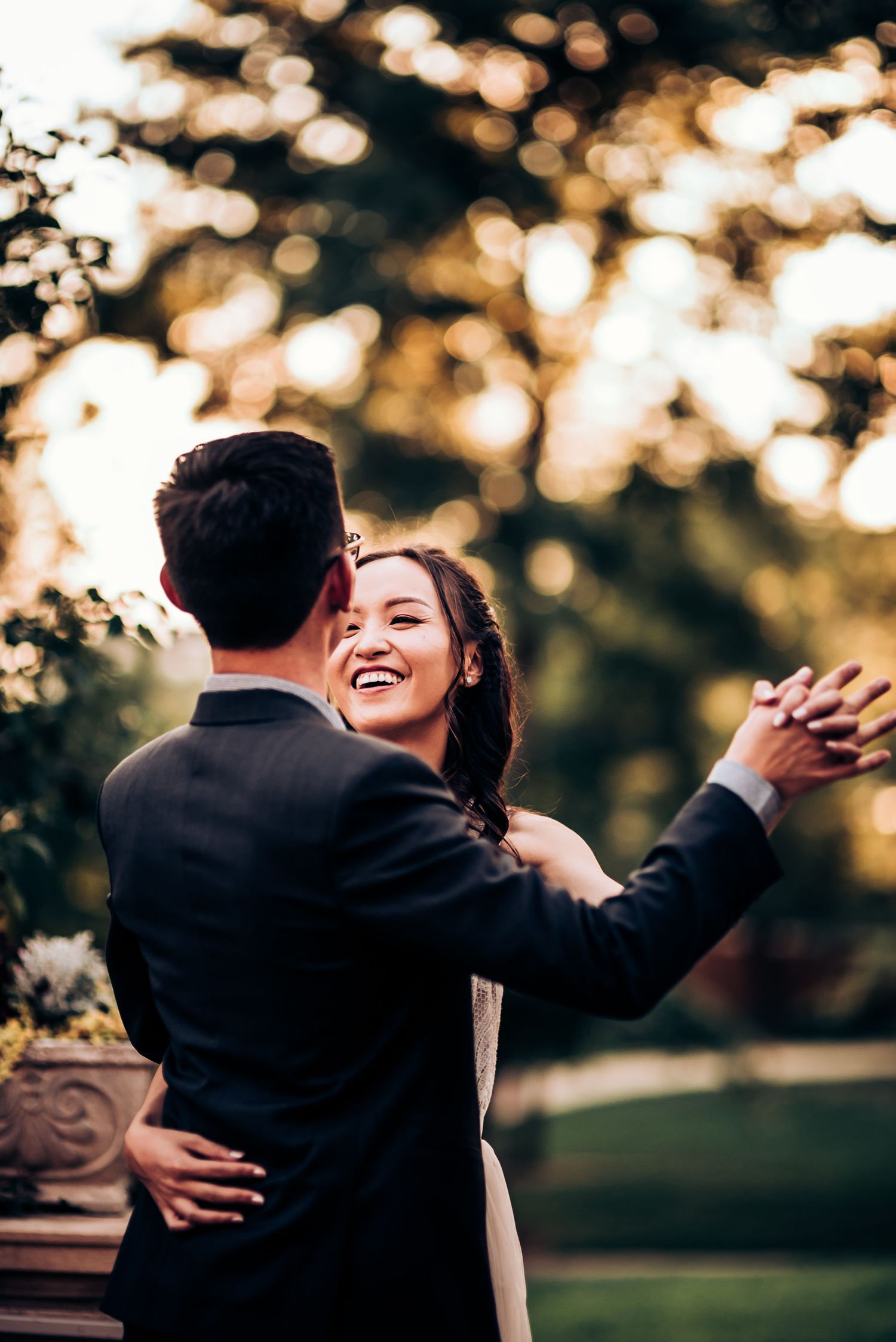 A romantic dance moment captured at sunset with bokeh lighting in an outdoor garden setting.