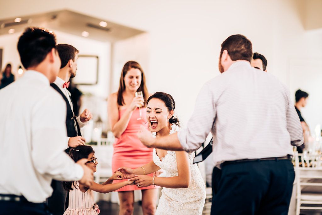 Lively wedding reception with guests laughing and socializing indoors.