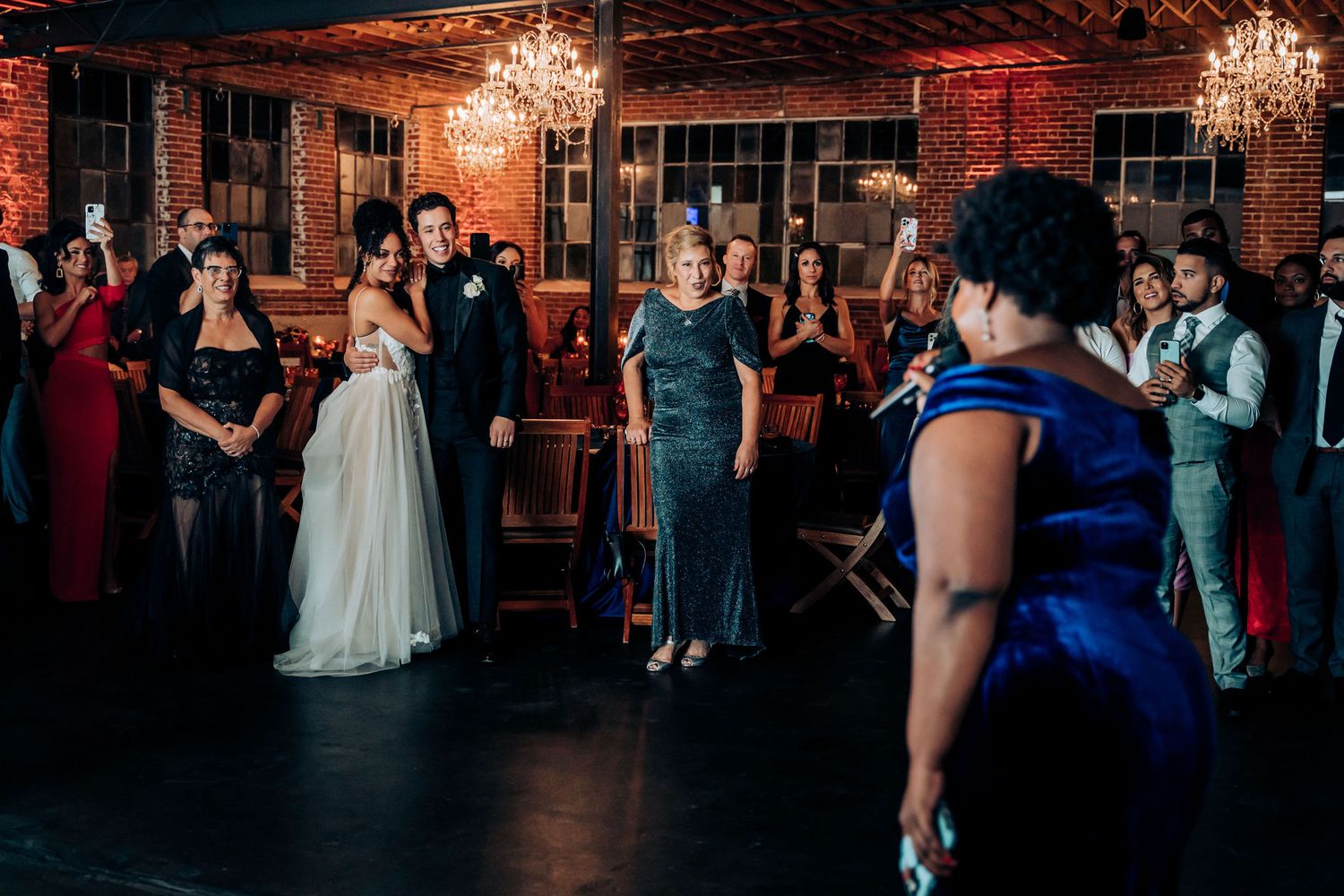 Reception celebration in an industrial-chic venue with brick walls and elegant lighting.