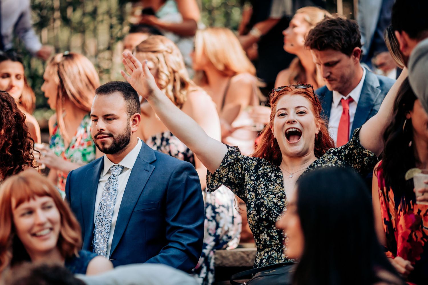 Joyful crowd celebrating and laughing during an outdoor event.