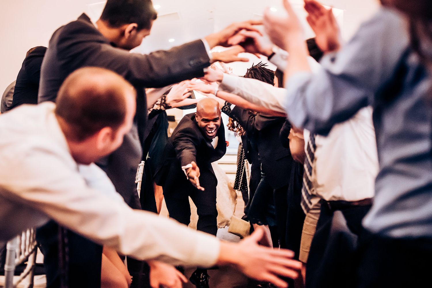 Dynamic group shot of guests interacting during wedding celebration festivities.