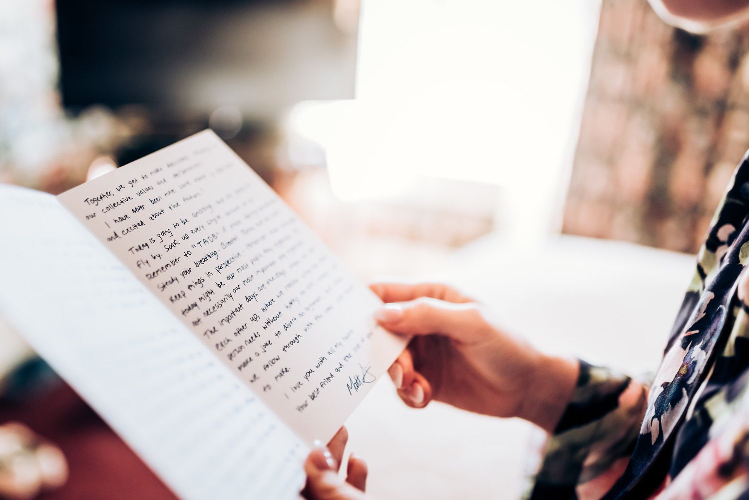 Hands holding handwritten letter with cursive text.