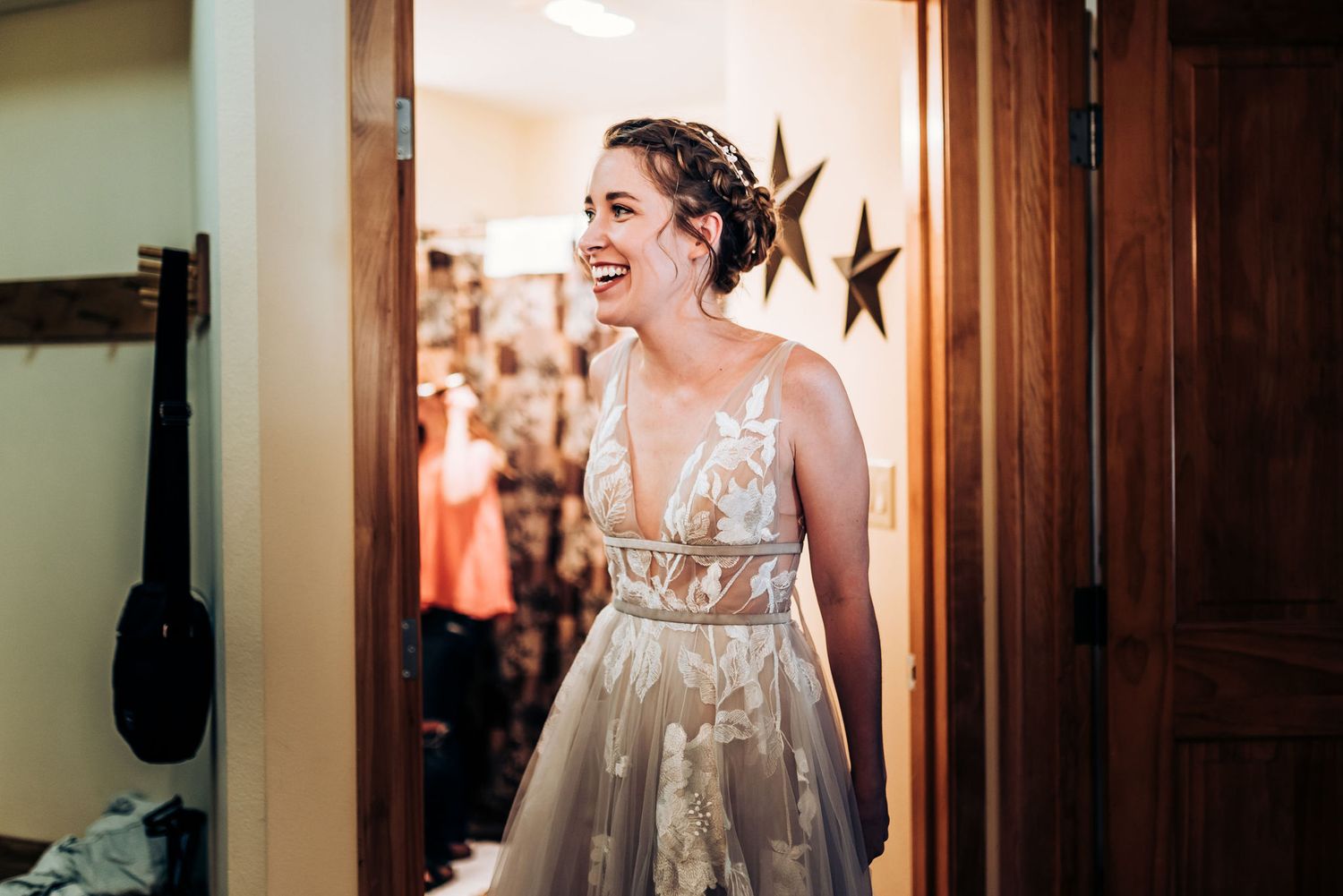 A candid moment of joy during wedding preparations in a doorway.