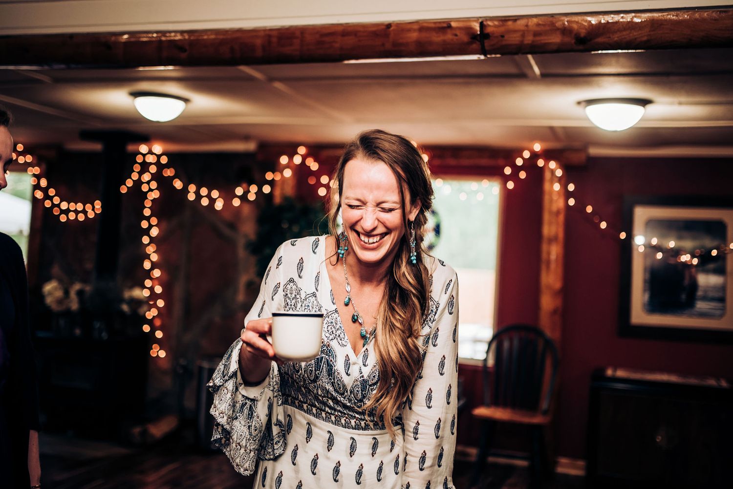 A joyful celebration moment captured under warm string lights at an indoor venue.