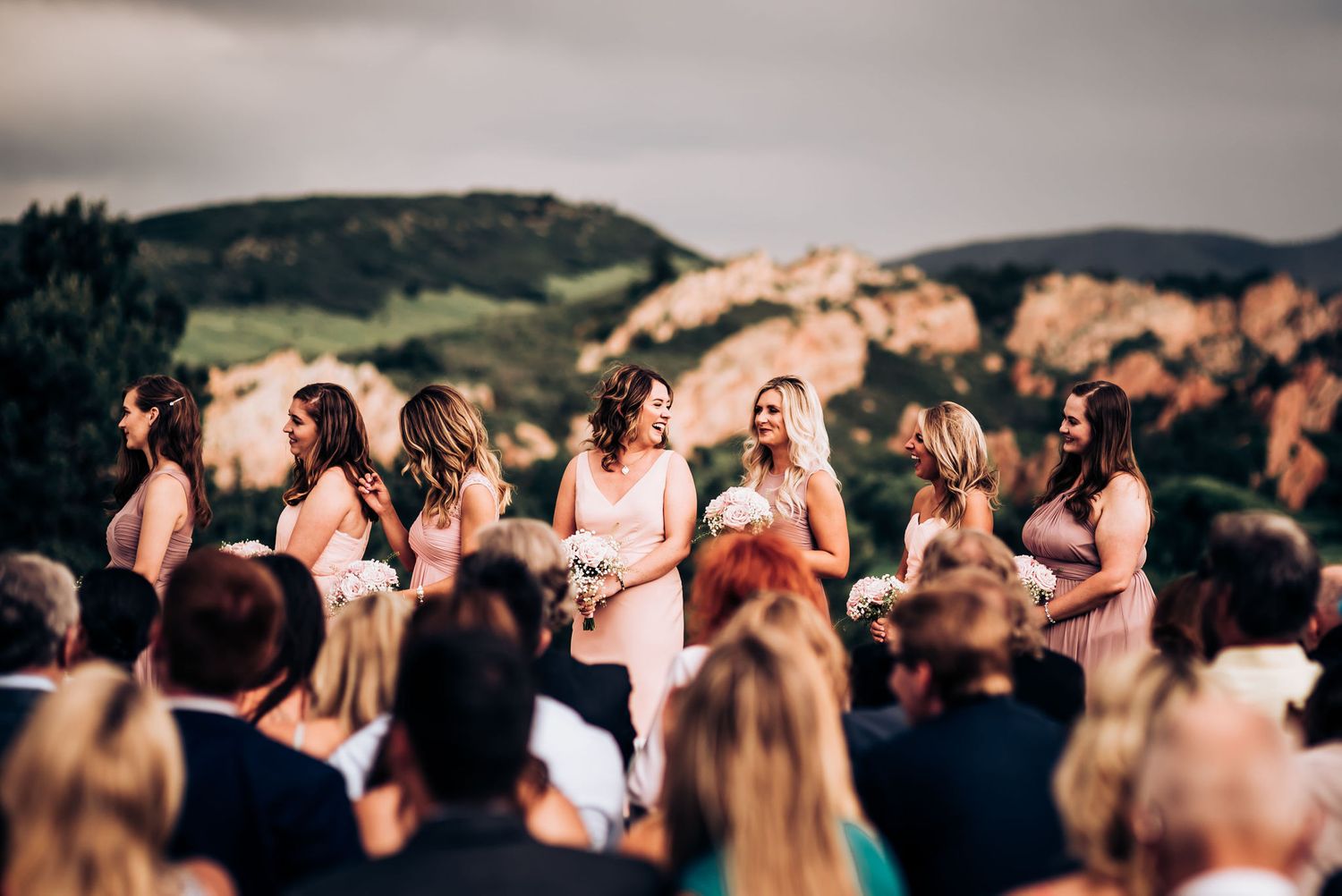 Wedding celebration with guests gathered outdoors against a mountainous backdrop.