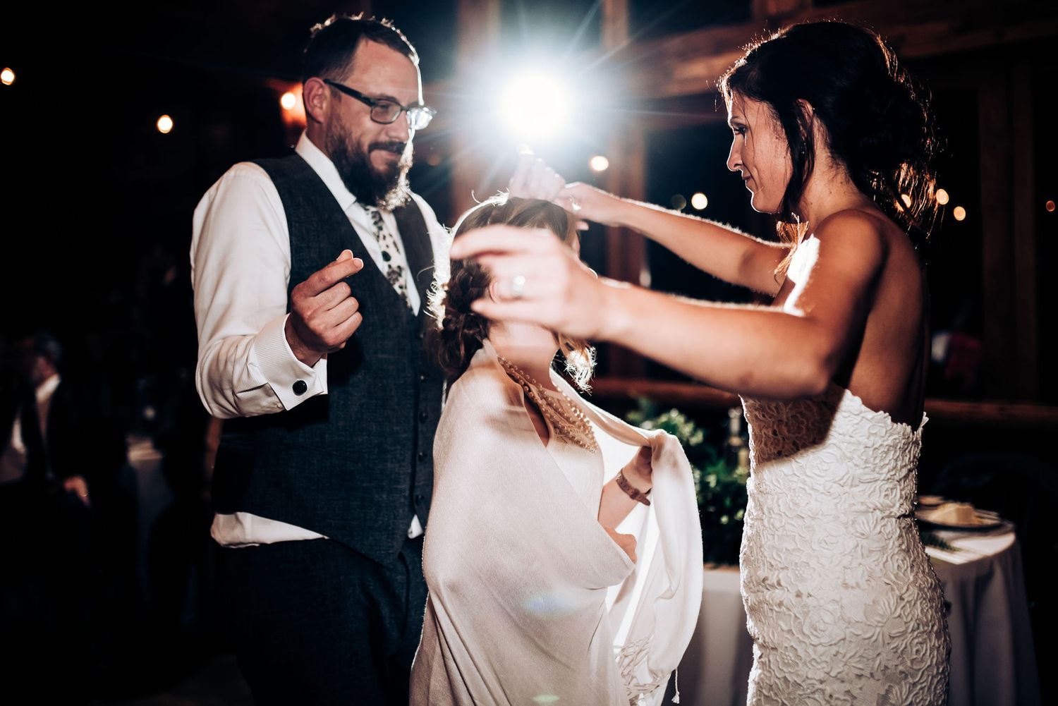 A playful moment during wedding festivities as guests share a laugh on the dance floor.