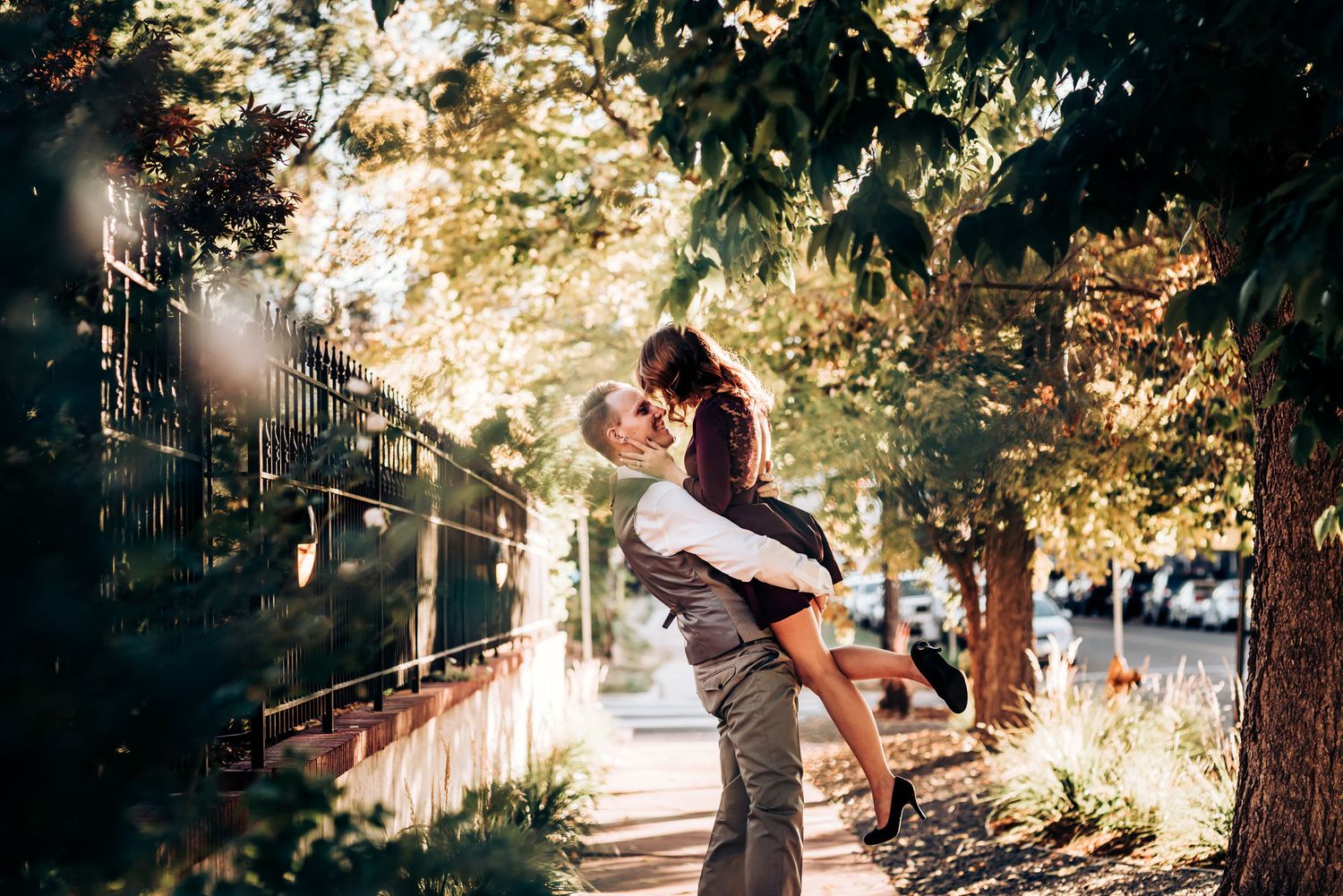 A joyful couple embraces on outdoor steps during golden hour.