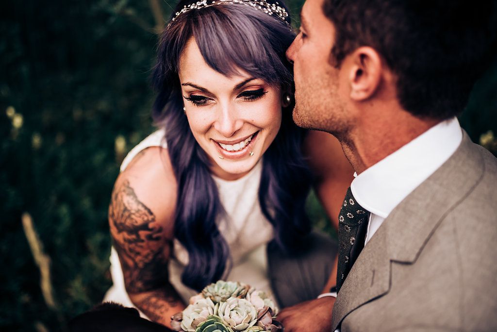 Joyful wedding moment captured with natural lighting and dark background.