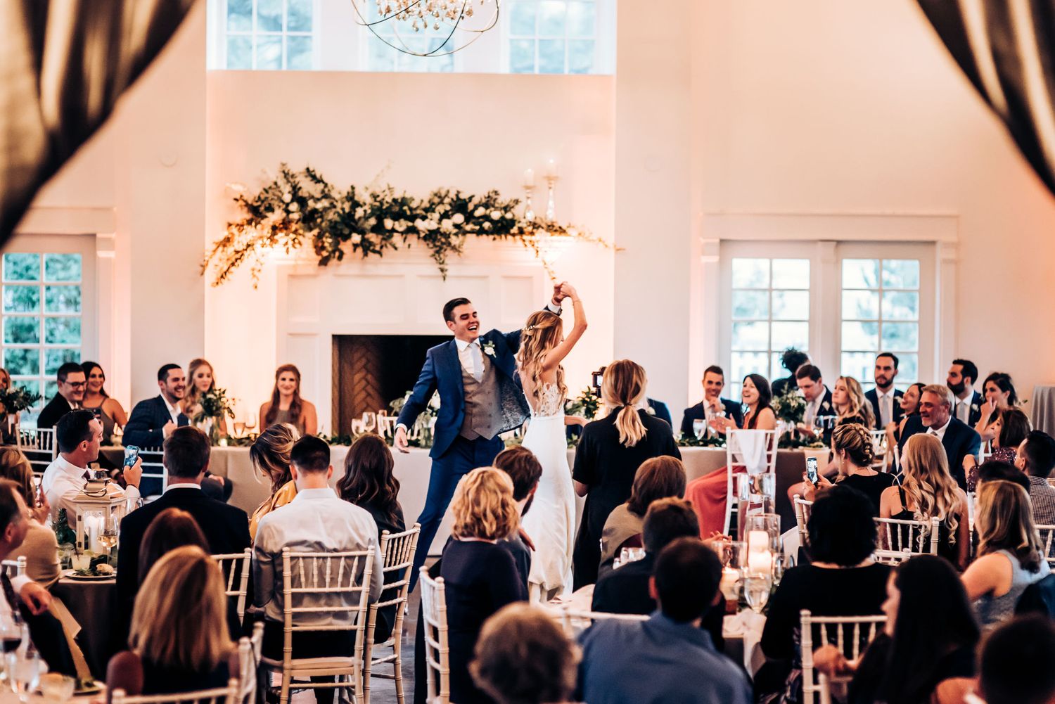 Wedding guests cheer as the couple dances during their reception celebration.