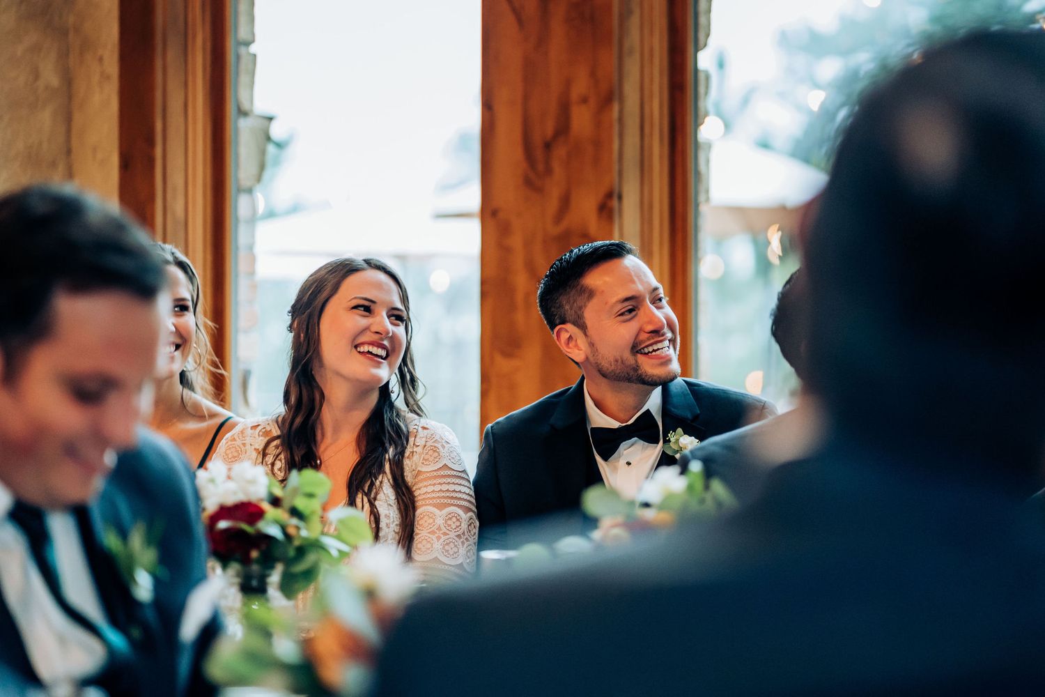 Candid moment of laughter during wedding reception speeches.
