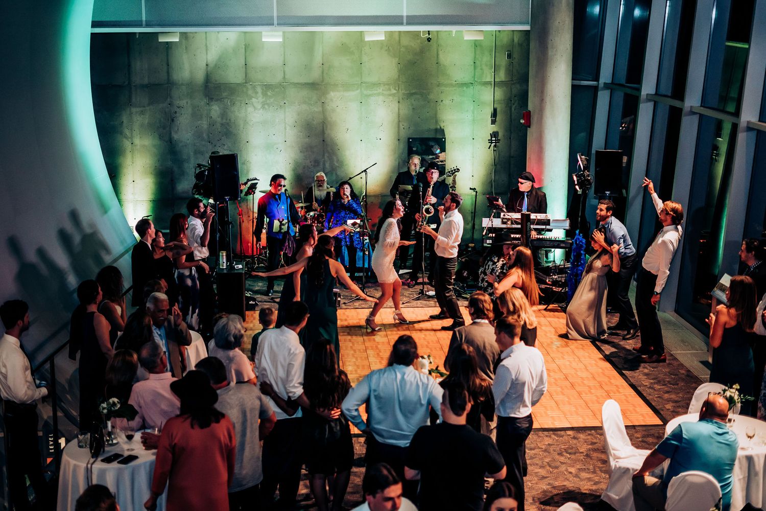 Overhead view of wedding reception dance floor filled with dancing guests and atmospheric lighting.
