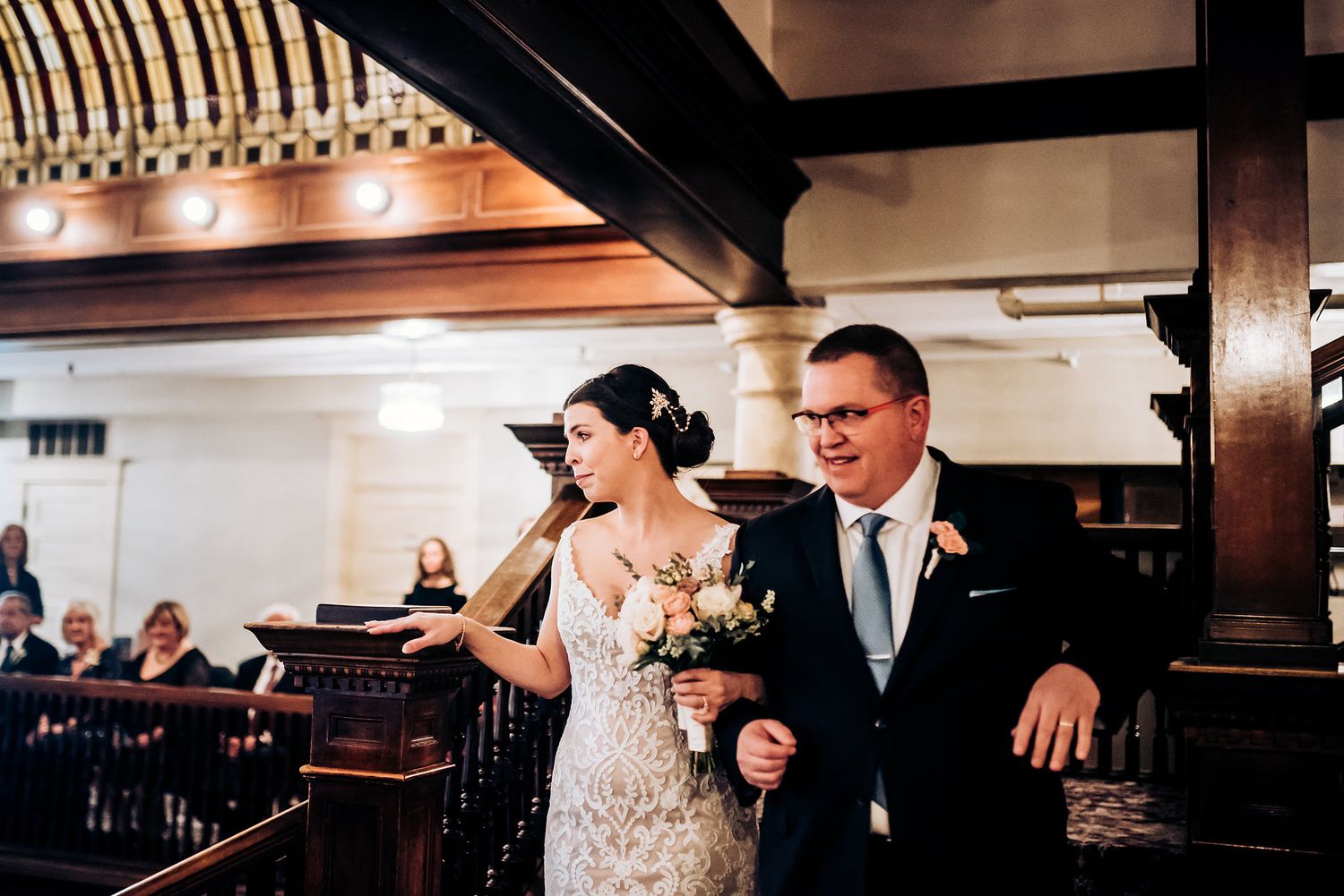 An emotional moment captured during a celebration on an ornate wooden staircase.