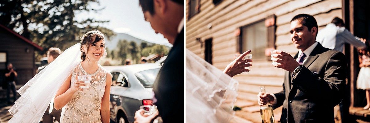 Wedding ceremony takes place outside a rustic wooden building on a sunny day.