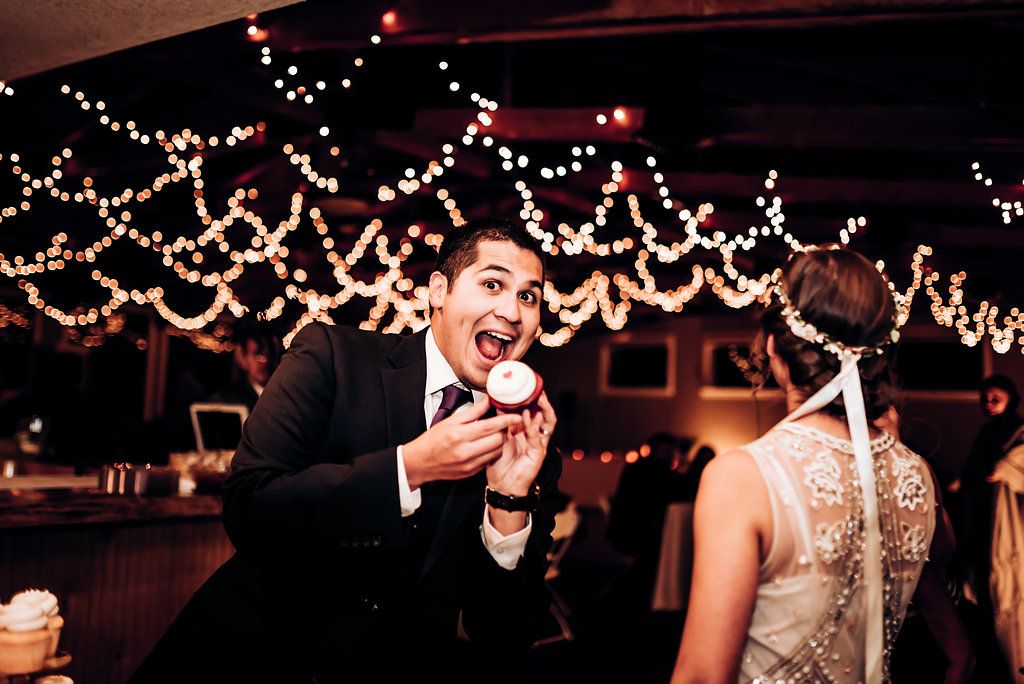 Candid reception moment with string lights creating festive atmosphere.