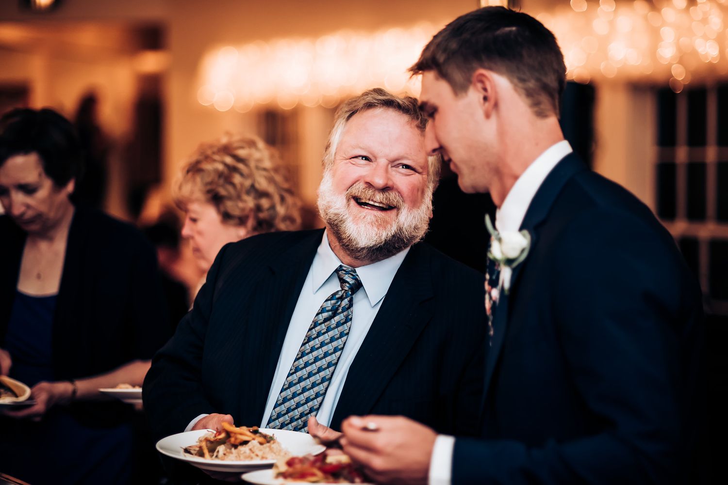 Guest sharing a jovial moment during wedding reception dinner.