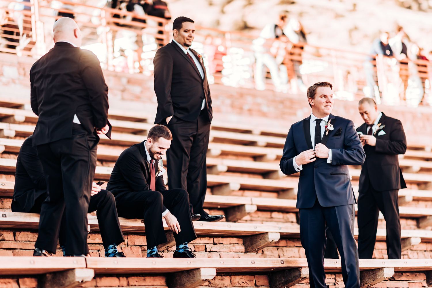 Groomsmen gathered on the historic stone steps of Red Rocks amphitheater.